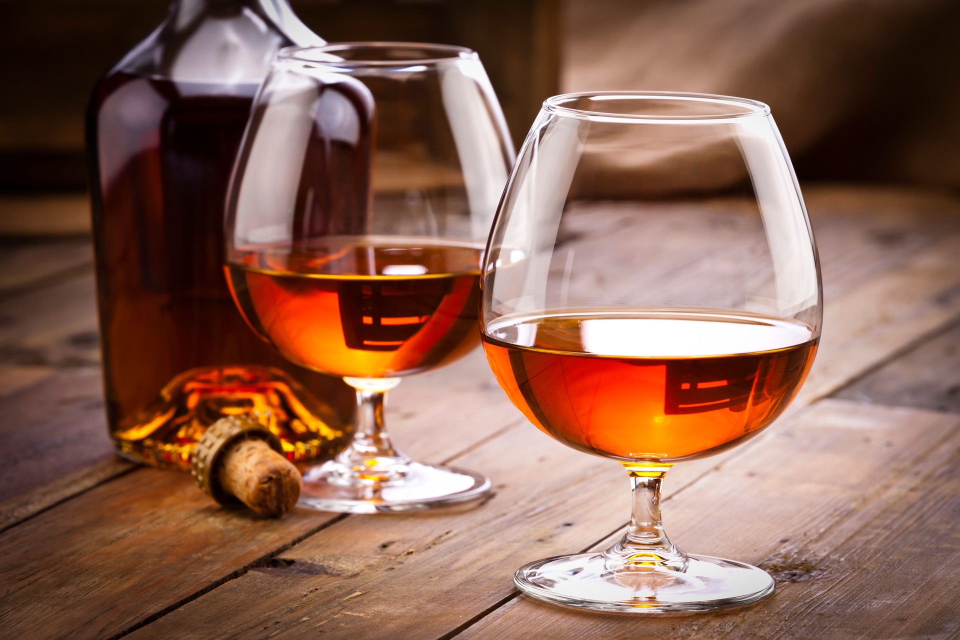 Cognac snifters with bottle on rustic wood table