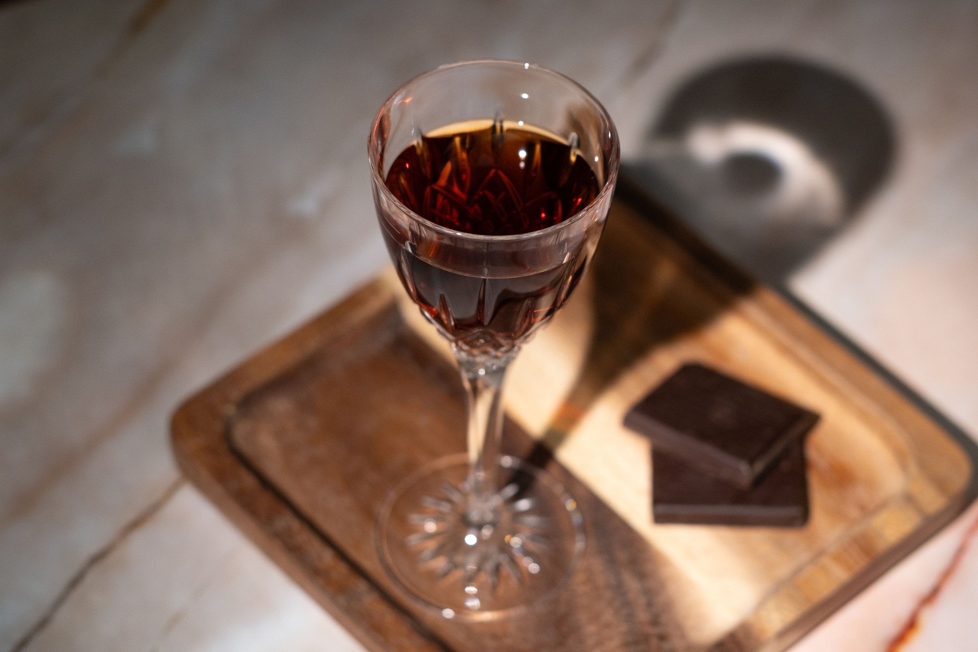 Sherry liqueur glass on wooden plate with chocolate